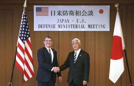 U.S. Defense Secretary Ash Carter, left, and Japan's Defense Minister Gen Nakatani, right, shake hands prior to a meeting at the Defense Ministry in Tokyo, Wednesday, April 8, 2015. REUTERS/Eugene Hoshiko/Pool