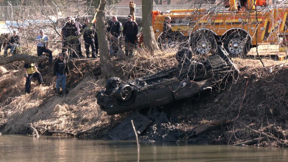 Winnebago County Sheriff's deputies and dive team members watch Monday, March 11, 2024, as a crane pulls a brown 1966 Chevrolet Impala from the Pecatonica River near the corner of East First and Washington streets in Pecatonica.