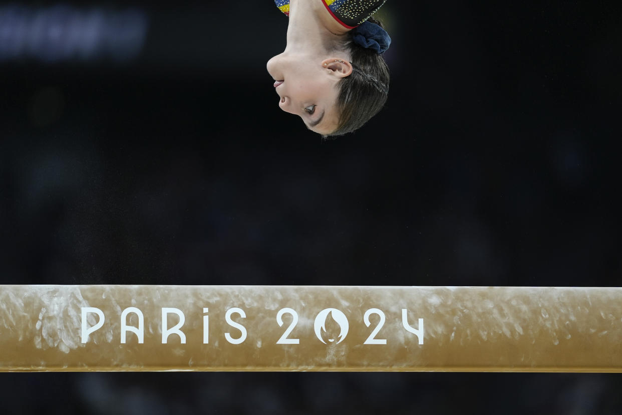 The head of Lilia Cosman, of Romania, facing downward at the balance beam during a women's artistic gymnastics qualification round.