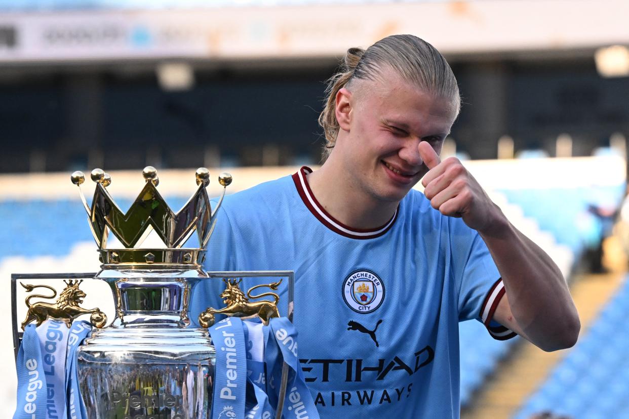 Manchester City striker Erling Haaland poses with the Premier League trophy on the pitch after the presentation ceremony. 