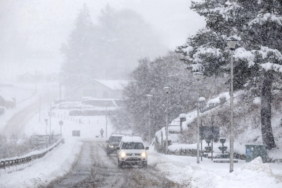 LAIRG, SCOTLAND - JANUARY 18: Cars make their way through the snow as the Met Office issued weather alerts for snow as low temperatures continue across the north of the country on January 18, 2024 in Lairg, Scotland.  The Met Office issued a rare amber snow warning for north-west Scotland as the UK experienced near-record low temperatures on Tuesday night, with the mercury falling to -14C. (Photo by Jeff J. Mitchell/Getty Images)