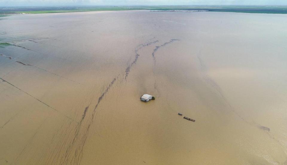 A barn is dwarfed by vast floodwaters in the old Tulare Lake basin area of Kings County south of Corcoran on Thursday, March 23, 2023.