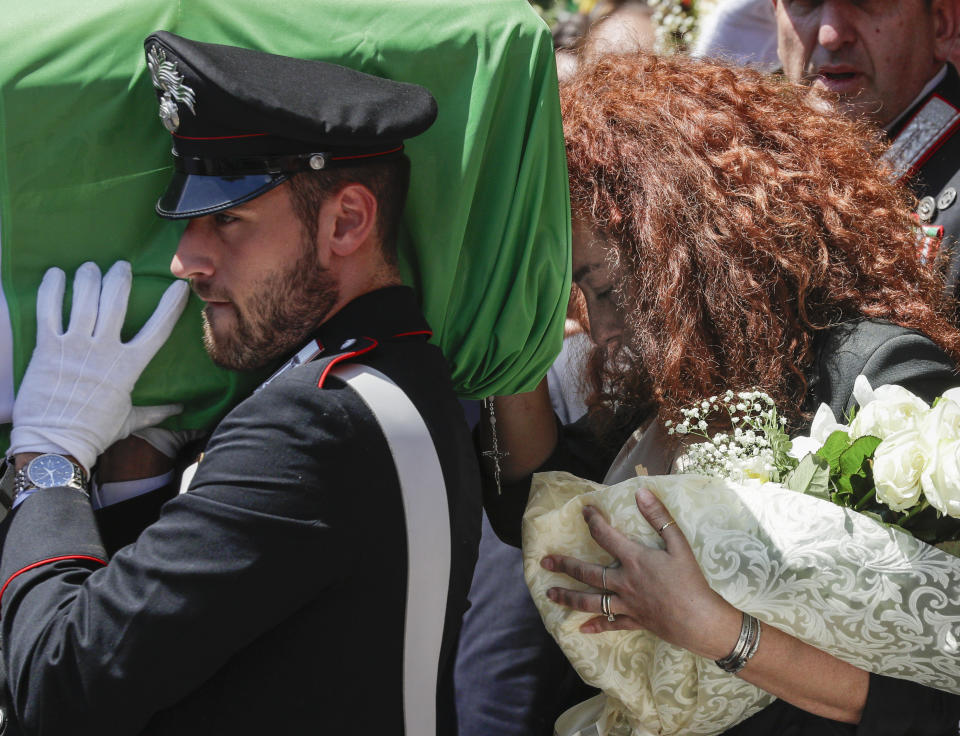 Carabinieri officer Mario Cerciello Rega's wife, Rosa Maria, right, follows the coffin containing the body of her husband during his funeral in his hometown of Somma Vesuviana, near Naples, southern Italy, Monday, July 29, 2019. Two American teenagers were jailed in Rome on Saturday as authorities investigate their alleged roles in the fatal stabbing of the Italian police officer on a street near their hotel. (AP Photo/Andrew Medichini)