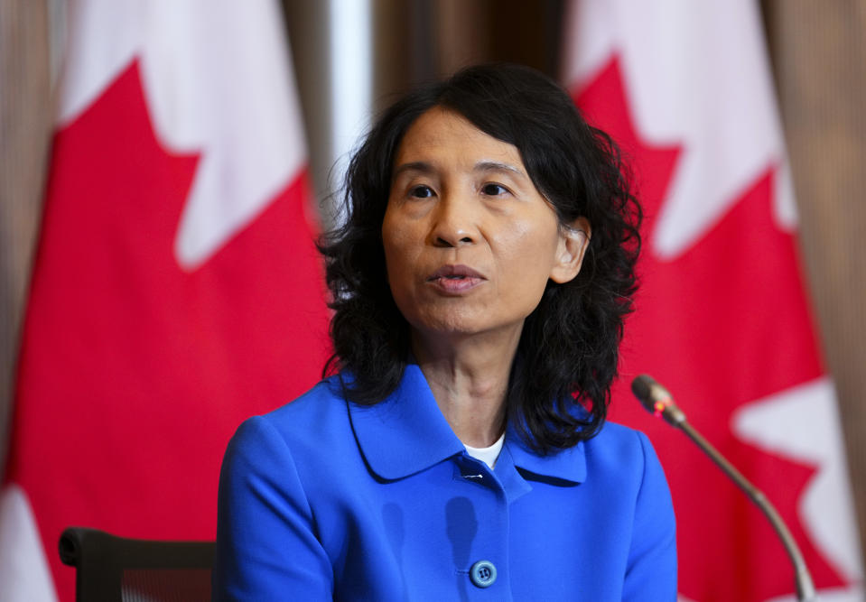 Dr. Theresa Tam in front of Canada flags while speaking about measles vaccines.