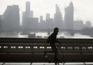 A scooter rider travels over Westminster Bridge in London, Saturday, Jan. 23, 2021 during England's third national lockdown since the coronavirus outbreak began. The U.K. is under an indefinite national lockdown to curb the spread of the new variant, with nonessential shops, gyms and hairdressers closed, and people being told to stay at home. (AP Photo/Kirsty Wigglesworth)