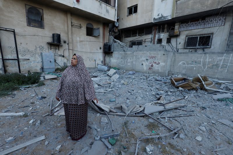 Una mujer mira parada junto a un edificio dañado donde el comandante senior del grupo militante de la Yihad Islámica Tayseer al-Jaabari murió debido a ataques israelíes, en la ciudad de Gaza