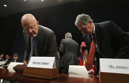 U.S. Director of National Intelligence James Clapper (L) looks for his name tag alongside Deputy Attorney General James Cole before their testimony at a House Intelligence Committee hearing on Capitol Hill in Washington, October 29, 2013. REUTERS/Jason Reed