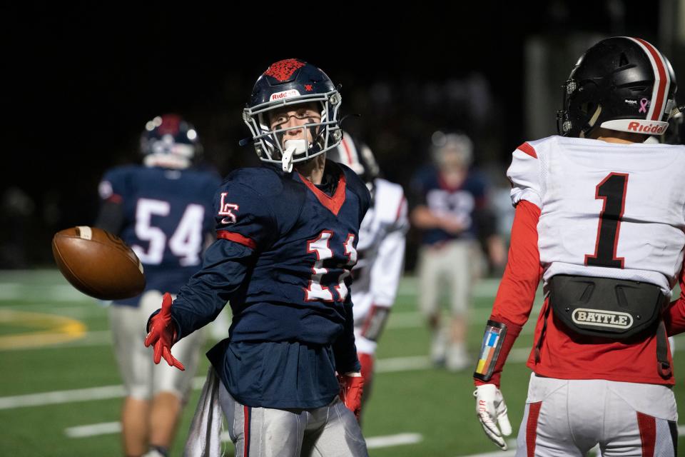 Lincoln-Sudbury senior captain Nolan O'Brien tosses the ball to an official after an offensive play, during the first round Division 2 playoff game against Wellesley at Myers Field in Sudbury, Nov. 5, 2021. The Warriors beat the Raiders, 42-0.