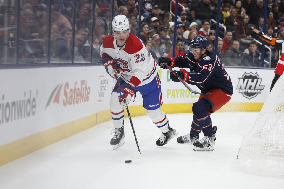 Montreal Canadiens' Juraj Slafkovsky, left, tries to control the puck as Columbus Blue Jackets' Jake Christiansen defends during the first period of an NHL hockey game Thursday, Nov. 17, 2022, in Columbus, Ohio. (AP Photo/Jay LaPrete)