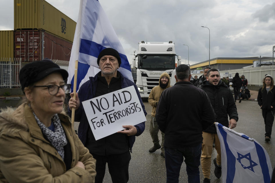 Israeli activists block the exit of Ashdod port to stop trucks they claim are carrying humanitarian aid destined for the Gaza Strip, in Ashdod, Israel, Thursday, Feb. 1, 2024. The activists say no aid should enter the territory until Israeli hostages held captive by the Hamas militant group are released. (AP Photo/Leo Correa)