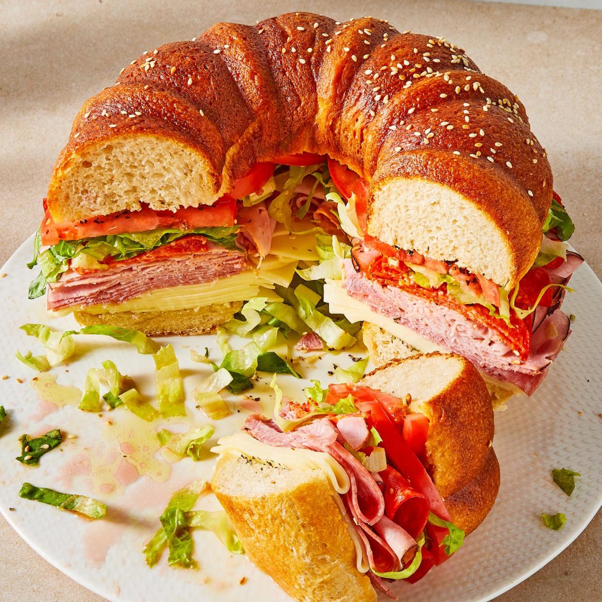 bundt cake bread filled with sliced salami, ham, provolone, tomatoes, lettuce, and pepperoni