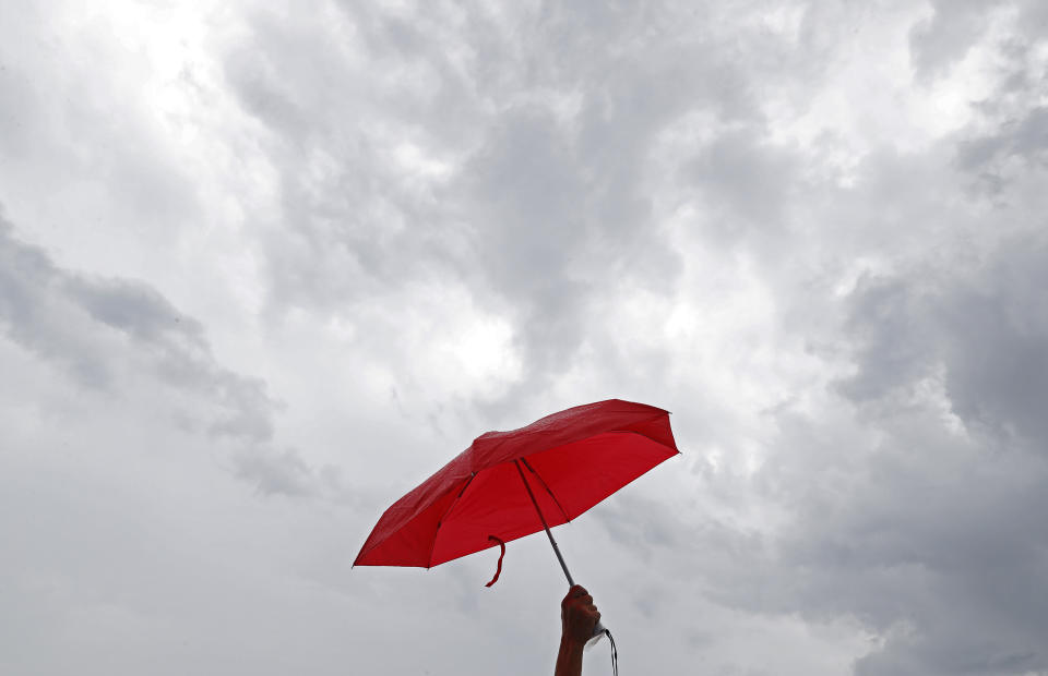 A pro-China supporter holds a red umbrellas during a counter-rally in support of the police in Hong Kong Saturday, July 20, 2019. Police in Hong Kong have raided a homemade-explosives manufacturing lab ahead of another weekend of protests in the semi-autonomous Chinese territory. (AP Photo/Vincent Yu)