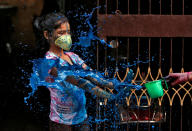 A girl wearing a protective mask reacts as she is splashed with coloured water during Holi celebrations amid coronavirus precautions, in Chennai, India, March 10, 2020. REUTERS/P. Ravikumar TPX IMAGES OF THE DAY