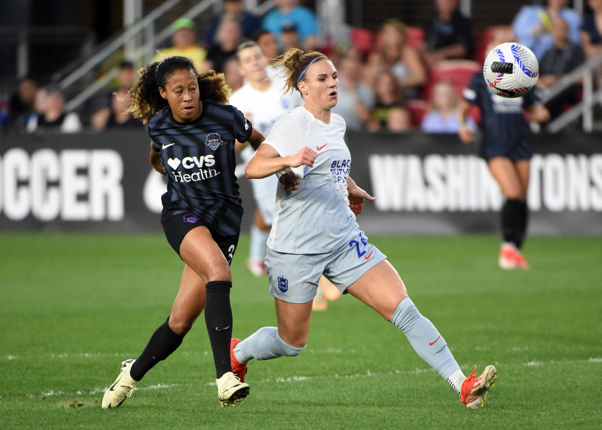 Washington Spirit midfielder Casey Krueger battles Seattle Reign midfielder Veronica Latsko for a loose ball during a NWSL game in May. (John Rivera/Getty Images)