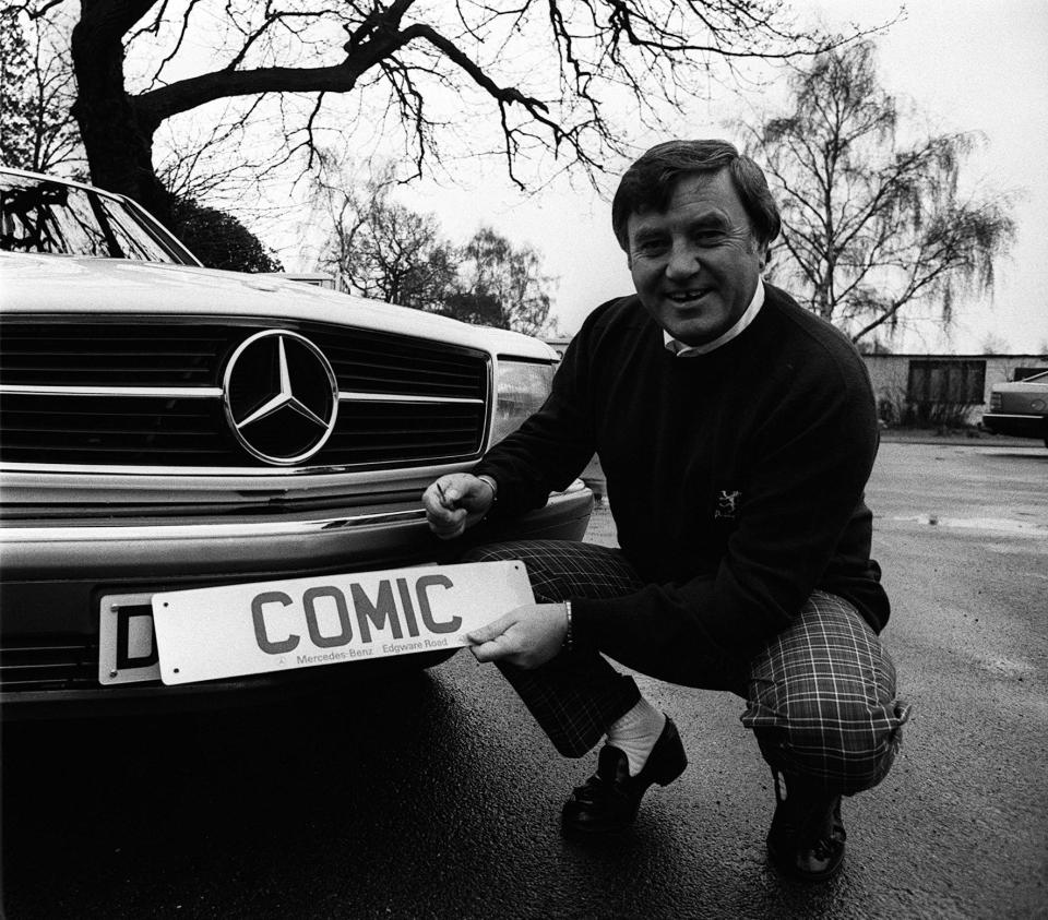 The comedian Jimmy Tarbuck with his famous number plate 'comic' which he is putting on his new Mercedes-Benz.