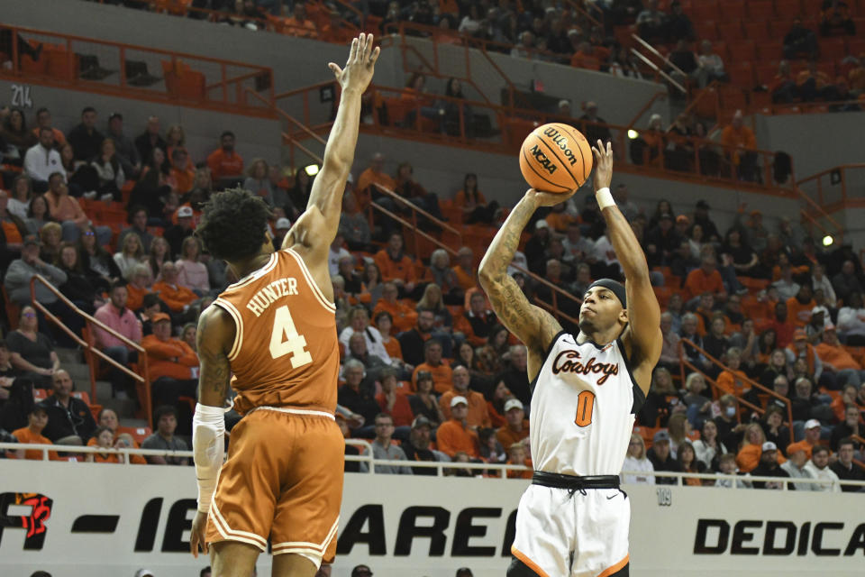 Oklahoma State guard Avery Anderson III (0) takes a shot while Texas guard Tyrese Hunter (4) defends during the first half NCAA college basketball game Saturday, Jan. 7, 2023, in Stillwater, Okla. Texas defeated Oklahoma State 56-46. (AP Photo/Brody Schmidt)