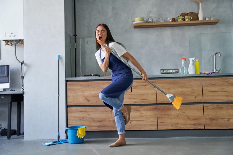 person singing into the broom stick