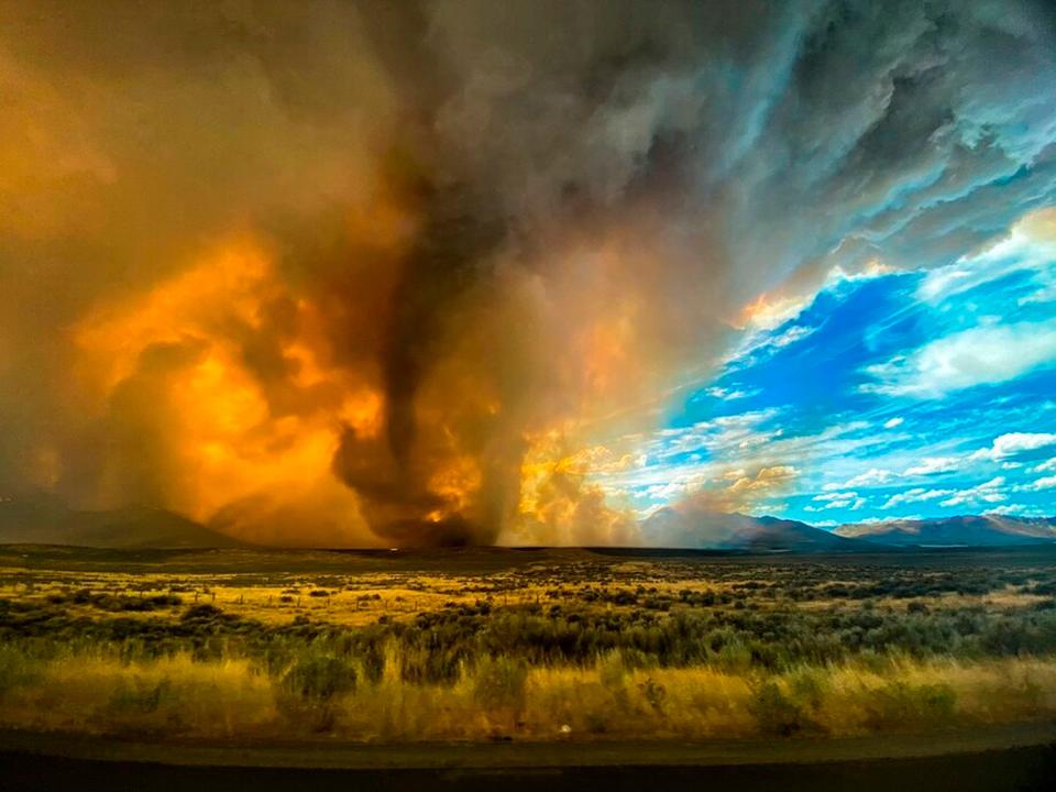 This photo provided by Katelynn & Jordan Hewlett, a funnel appears in a thick plume of smoke from the Loyalton Fire is seen in Lassen County, Calif., Saturday, Aug. 15, 2020. A wildfire in Northern California on Saturday spawned at least one fire tornado that prompted the National Weather Service to issue a tornado warning. The Loyalton Fire in Lassen County, Calif., burned intensely amid hot and dry conditions on Saturday afternoon. (Katelynn & Jordan Hewlett via AP) ORG XMIT: LA701