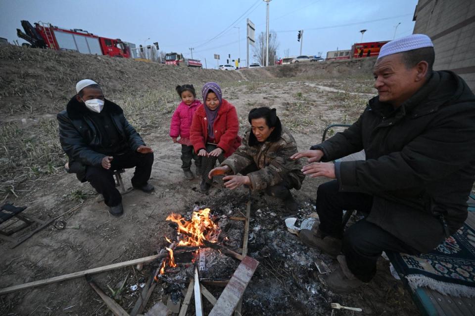 People gather next to a fire after an earthquake in Dahejia, Jishishan County in northwest China's Gansu (AFP via Getty Images)