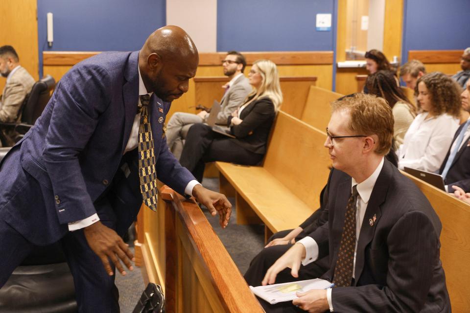 Special Prosecutor Nathan Wade, left, speaks with an aide, right, in the gallery during a hearing on motions from defendant Sydney Powell in front of Fulton County Superior Court Judge Scott McAfee in Atlanta, Thursday, Oct. 5, 2023. Nineteen people, including former President Donald Trump, were indicted in August and accused of participating in a wide-ranging illegal scheme to overturn the results of the 2020 presidential election. (Erik S. Lesser/Pool Photo, via AP)