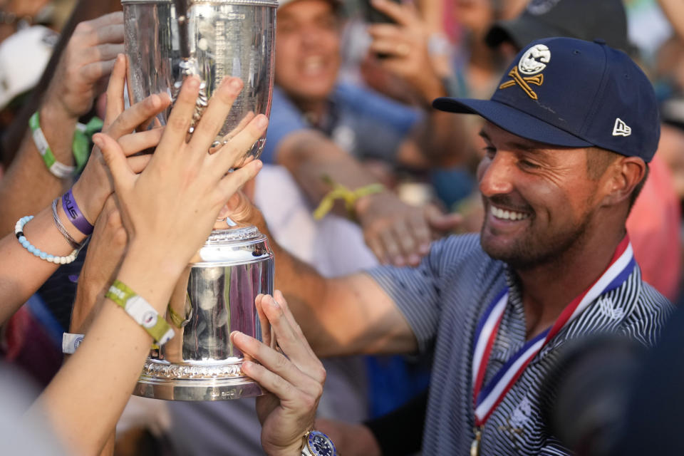 Bryson DeChambeau shows the trophy to fans after winning the U.S. Open golf tournament Sunday, June 16, 2024, in Pinehurst, N.C. (AP Photo/George Walker IV)