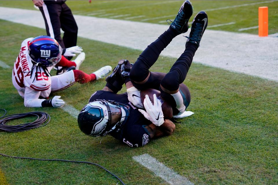 Philadelphia Eagles' DeVonta Smith, right, tumbles after catching a touchdown pass during the second half of an NFL football game against the New York Giants, Sunday, Dec. 26, 2021, in Philadelphia. (AP Photo/Laurence Kesterson)