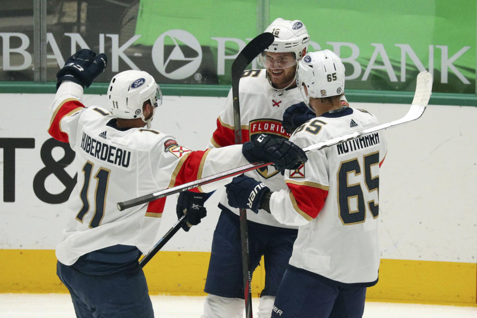 Florida Panthers left wing Jonathan Huberdeau (11) and defenseman Markus Nutivaara (65) celebrate the first-period goal by Aleksander Barkov (16) against the Dallas Stars during an NHL hockey game Tuesday, April 13, 2021, in Dallas. (AP Photo/Richard W. Rodriguez)