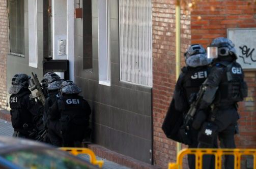 Spanish police prepare to raid the apartment building of the suspect. Source: AFP