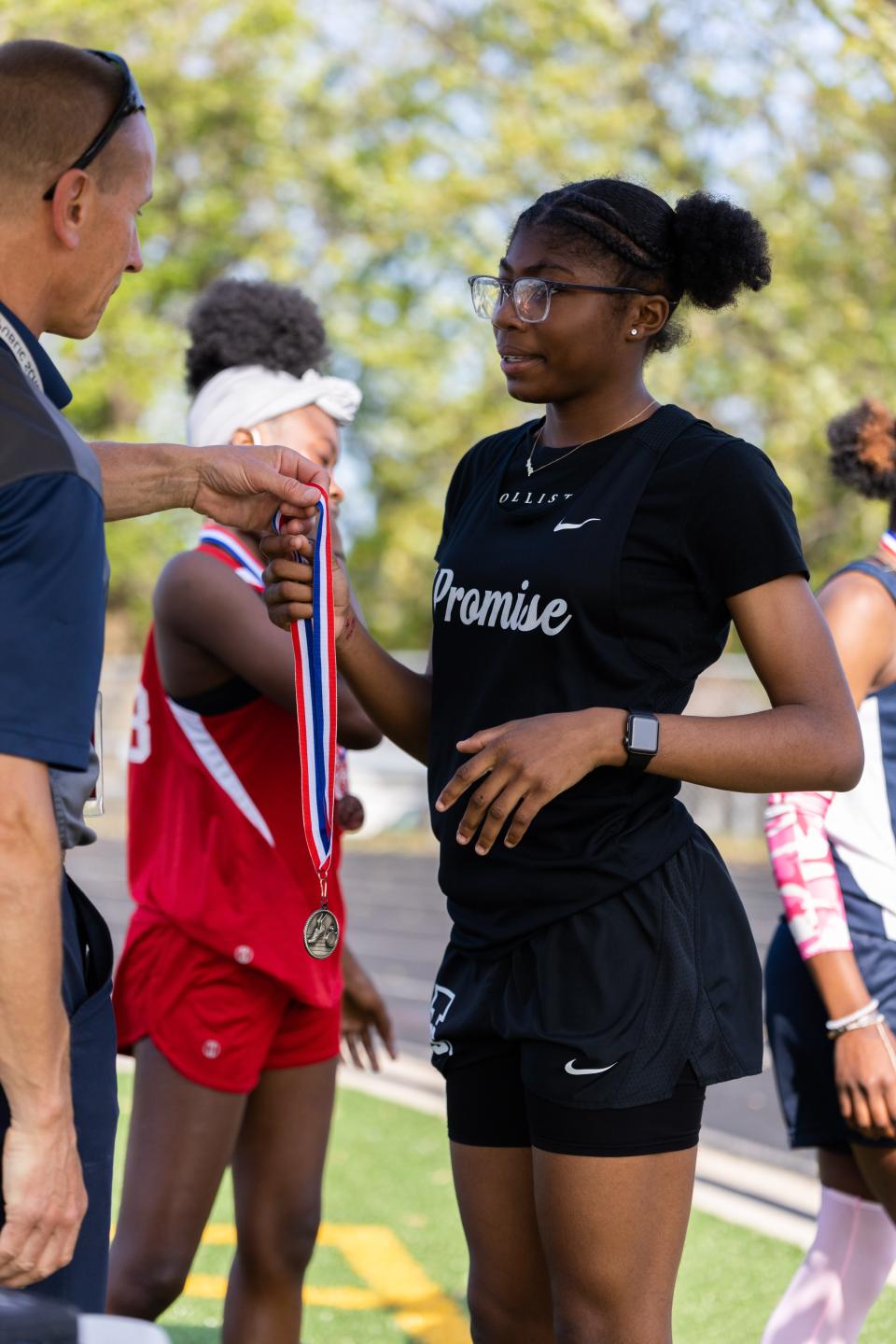 Miniya Mitchell receives a medal from Akron Public Schools athletic director Joe Vassalotti.