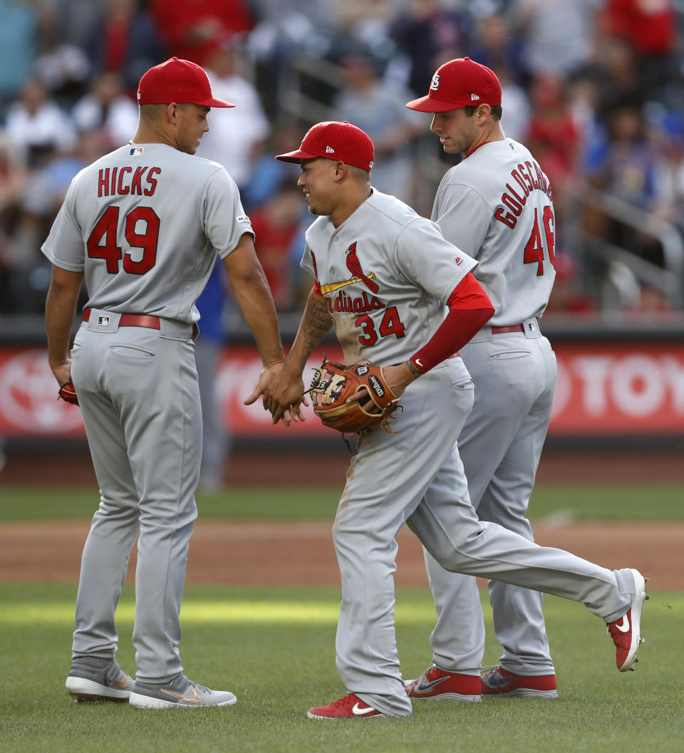 St. Louis Cardinals shortstop Yairo Munoz (34) celebrates with relief pitcher Jordan Hicks (49) and first baseman Paul Goldschmidt, right, after the Cardinals defeated the New York Mets 5-4 in the 10th inning of a baseball game Friday, June 14, 2019, in New York, that had been suspended Thursday because of rain. (AP Photo/Kathy Willens)