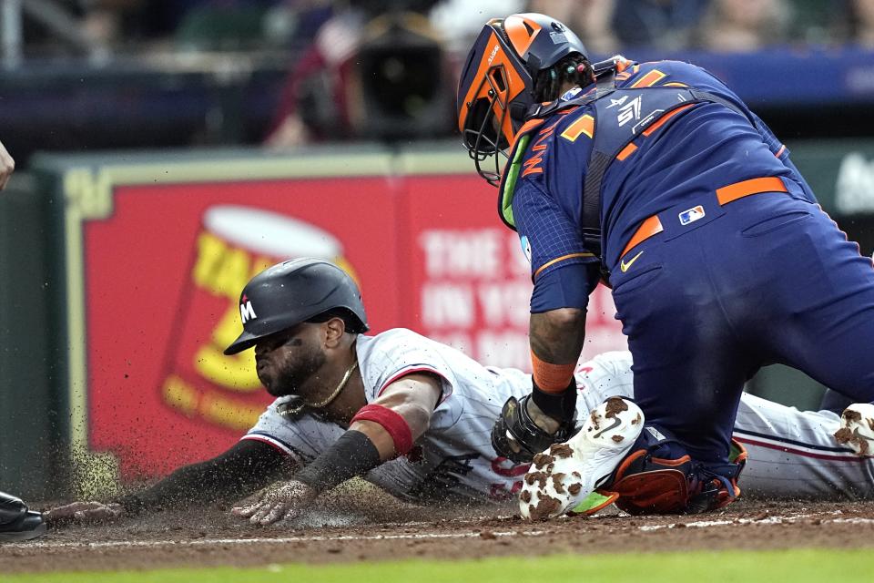 Minnesota Twins' Willi Castro left, scores as Houston Astros catcher Martin Maldonado reaches to tag him during the fourth inning of a baseball game Monday, May 29, 2023, in Houston. (AP Photo/David J. Phillip)