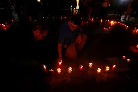 People place candles on the ground during a silent candlelight vigil to protest against the assassination of investigative journalist Daphne Caruana Galizia in a car bomb attack two days ago, at the University of Malta in Msida, Malta, October 18, 2017. REUTERS/Darrin Zammit Lupi