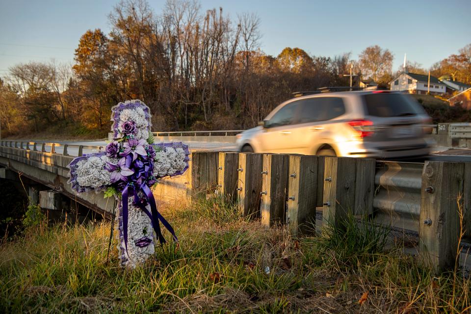 A vehicle passes a cross in memory of Dario Carvajal Dominguez on U.S. 19 in Woodfin, November 1, 2023.