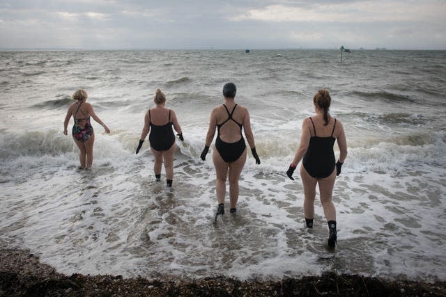 Swimmers take their daily dip in the Thames estuary at Thorpe Bay near Southend On Se