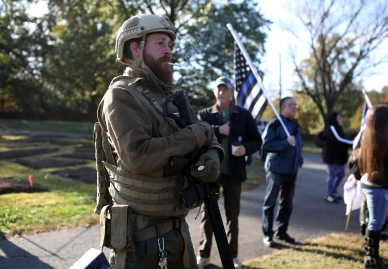 A man carries a rifle as militia members and pro-gun rights activists participating in the "Declaration of Restoration" rally prepare to march to Washington, D.C. from Arlington, Virginia