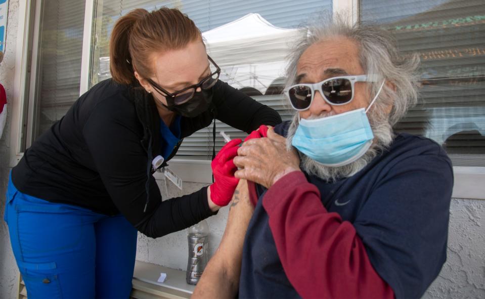 In this 2020 file photo, LVN nursing coordinator Samantha Sola gives a COVID-19 vacation shot to Donald Regpala, who was temporality housed at the Motel 6 on Martin Luther King Jr. Boulevard in Stockton under the statewide Project Roomkey program.