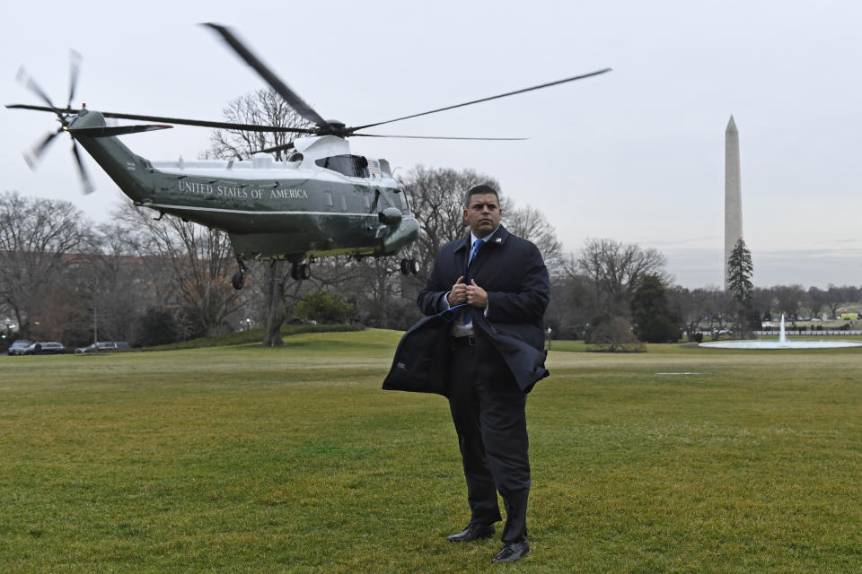 A U.S. Secret Service agents holds on to his coat as Marine One, with President Donald Trump and first lady Melania Trump on board, lifts off from the South Lawn of the White House in Washington, Monday, Jan. 13, 2020. The Trumps are heading to New Orleans to attend the College Football Playoff National Championship between Louisiana State University and Clemson. (AP Photo/Susan Walsh)