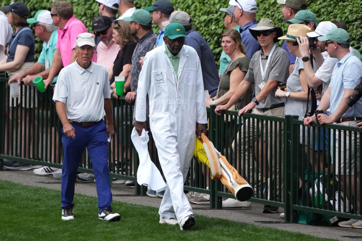 Ben Crenshaw walks with caddie Carl Jackson during the Par 3 Contest at the 2023 Masters. Jackson is one of a host of caddies featured in a re-released book by former Augusta Chronicle sports editor Ward Clayton.