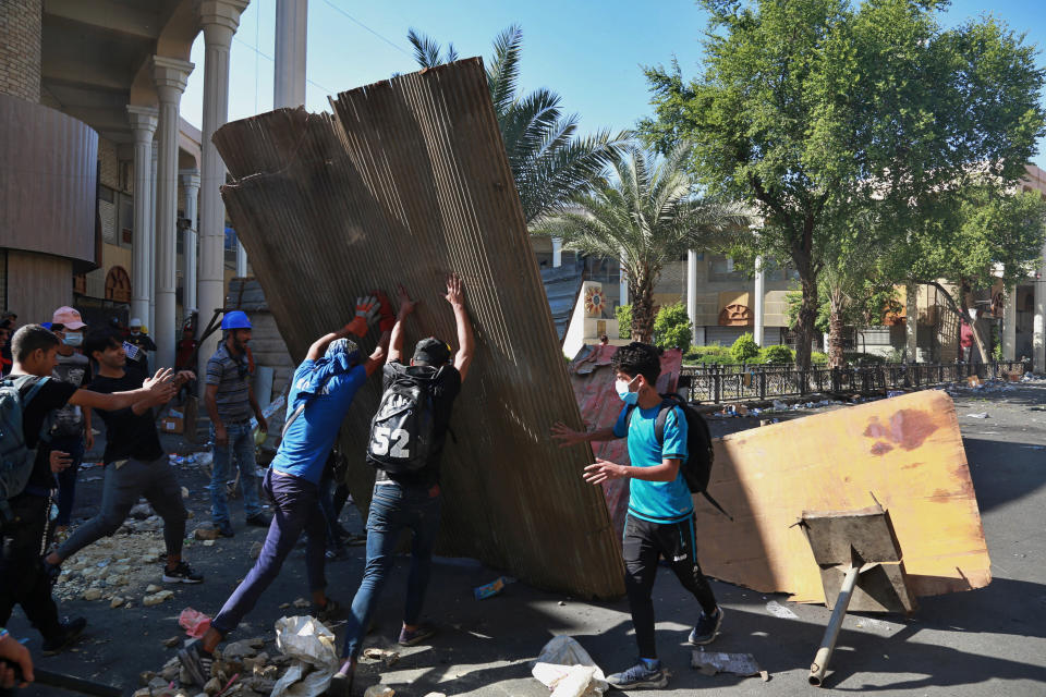 Protesters set barriers during clashes between Iraqi security forces and anti-government protesters in the al-Rasheed street in Baghdad, Iraq, Friday, Nov. 8, 2019. The demonstrators complain of widespread corruption, lack of job opportunities and poor basic services, including regular power cuts despite Iraq's vast oil reserves. They have snubbed limited economic reforms proposed by the government, calling for it to resign. (AP Photo/Khalid Mohammed)