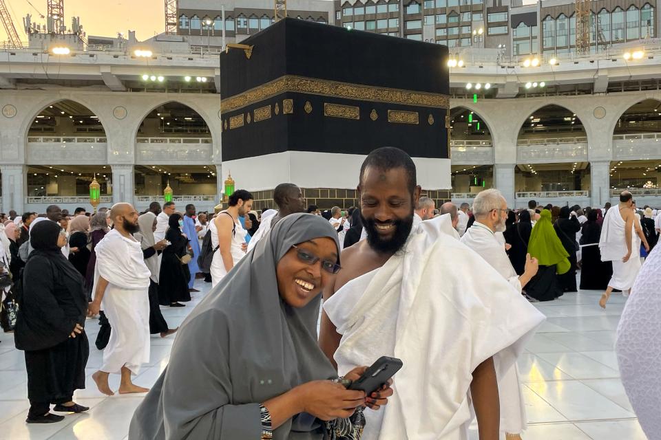 Somalian pilgrims prepare for a selfie in front of the Kaaba, the cubic building at the Grand Mosque, during the annual hajj pilgrimage in Mecca, Saudi Arabia, Monday, June 26, 2023.