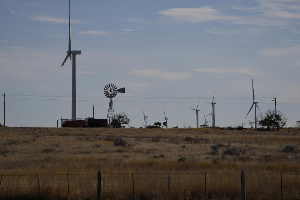 Wind turbines tower over a traditional windmill on a ranch near Del Rio, Texas, Friday, Feb. 17, 2023. Some landowners along the Devil's River argue that proposed wind turbines would kill birds, bats and disrupt monarch butterflies migrating to Mexico and impact ecotourism, a main source of income for many. (AP Photo/Eric Gay)