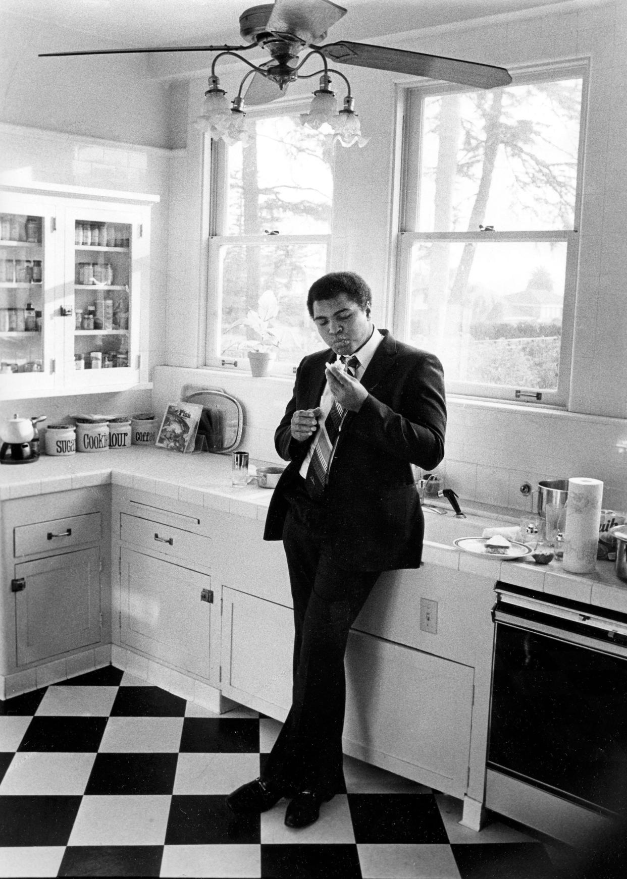 In this photo by Henderson Community College graduate and (later) Louisville Courier-Journal photojournalist Keith Williams shows former heavyweight champion Muhammad Ali eating a sandwich in the privacy of his kitchen at his home in California in 1980.