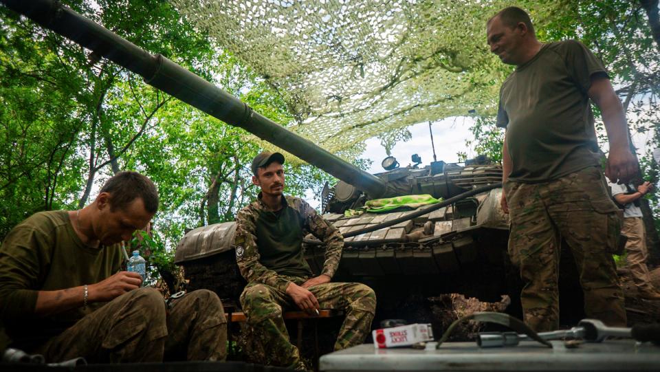 Members of Ukraine's 59th Separate Motorized Infantry Brigade named after Yakiv Handziuk during repair work on a tank near a frontline in the Donetsk direction (EPA)