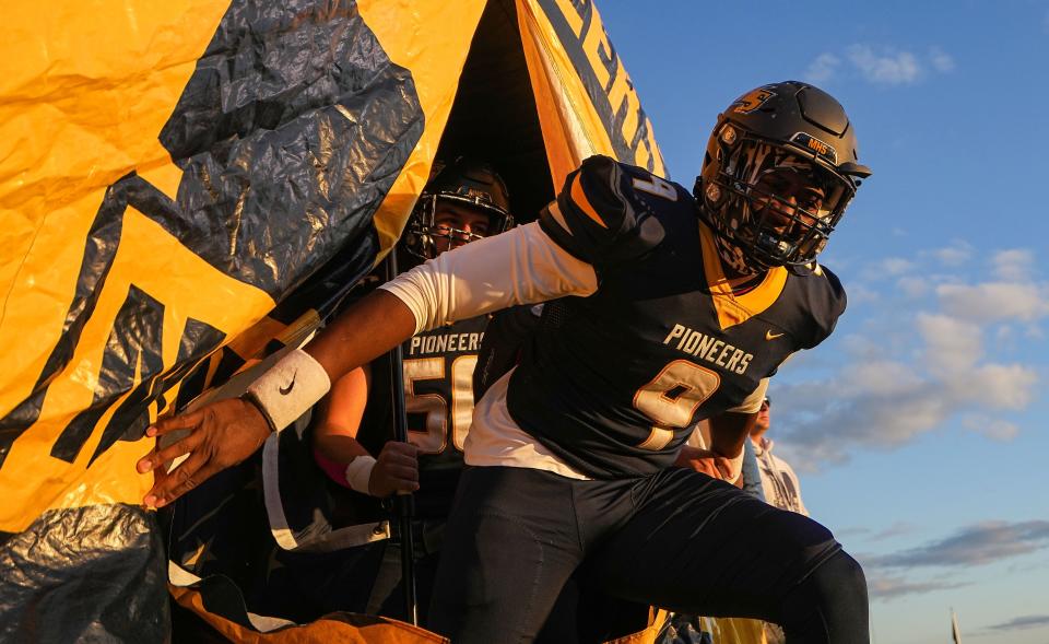 Mooresville Pioneers Nick Patterson (9) rushes onto the field Friday, Oct. 7, 2022, at Mooresville High School in Mooresville. The Mooresville Pioneers defeated the Martinsville Artesians in overtime, 37-31.