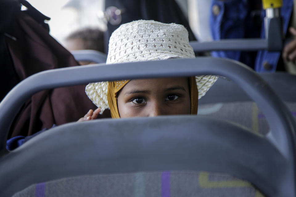 Somalis who fled the conflict in Sudan sit in a bus after arriving back home at the airport in Mogadishu, Somalia Sunday, April 30, 2023. 148 Somali nationals, mostly students, fleeing violence in Sudan arrived back home by plane on Sunday from the Ethiopian capital Addis Ababa, after a land trip from Sudan via Ethiopia facilitated by the Somali government. (AP Photo/Farah Abdi Warsameh)