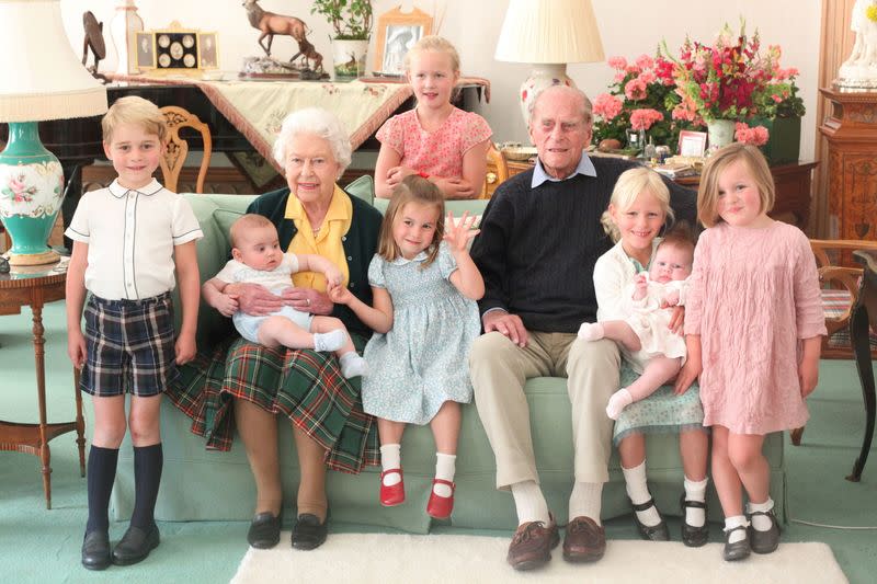 Britain's Queen Elizabeth and Prince Philip sit with Prince George, Prince Louis, Savannah Phillips, Princess Charlotte, Isla Phillips, Lena Tindall, and Mia Tindall