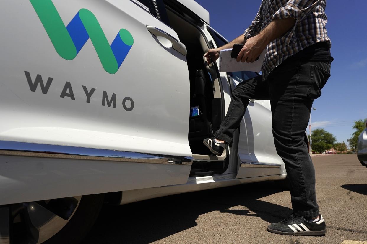 A Waymo minivan arrives to pick up passengers for an autonomous vehicle ride.