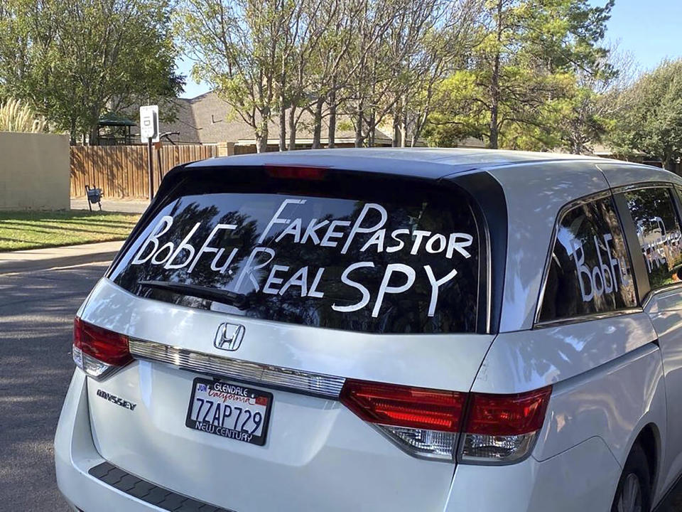 A van parked outside Bob Fu's home in Midland, Texas in the Fall of 2020, accuses the Chinese-American Christian pastor of being a spy for the Chinese Communist Party. American officials say foreign countries like Iran and China intimidate, harass and sometimes plot violence against political opponents and activists in the U.S. Fu, whose organization, ChinaAid, advocates for religious freedom in China, said he has endured far-ranging harassment campaigns for years. Large crowds arriving at his home by bus in well-coordinated actions he believes can be linked to the Chinese government. (Bob Fu via AP)