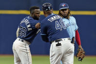 Tampa Bay Rays' Randy Arozarena (56) celebrates with first base coach Ozzie Timmons (40) after his double off Toronto Blue Jays pitcher Ross Stripling during the third inning of a baseball game Wednesday, Sept. 22, 2021, in St. Petersburg, Fla. Looking on is Blue Jays' Vladimir Guerrero Jr.(AP Photo/Chris O'Meara)