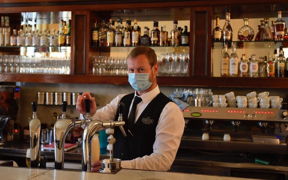 A barman in Berlin pours a beer as Germany, which has just 430 new cases per day, reopens following its coronavirus lockdown restrictions - Tobias Schwarz/AFP